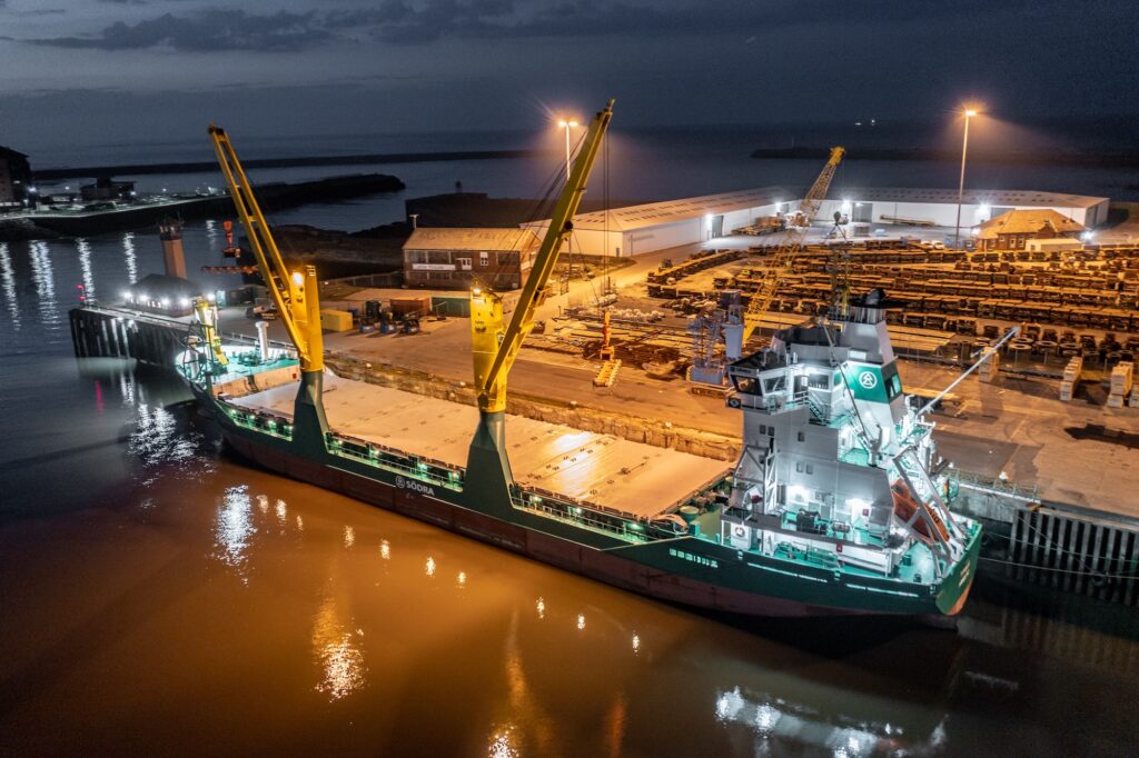 Cargo Ship Docked at a Port at Night Offloading Cargo